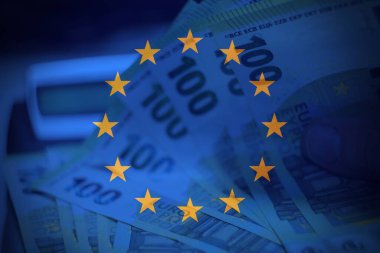 AB bayrağı altında avro banknotlarını gösteren Avrupa finans gücünün sembolik temsili, pazarlar, düzenlemeler ve kıtasal ekonomi konuları için ideal.