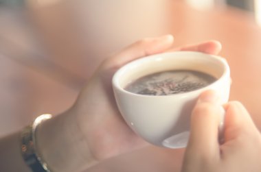 Bir fincan kahve arka plan tutan kadın bulanıklık.