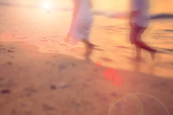 Casal de borrão de movimento correndo na praia tropical do por do sol com luz solar — Fotografia de Stock