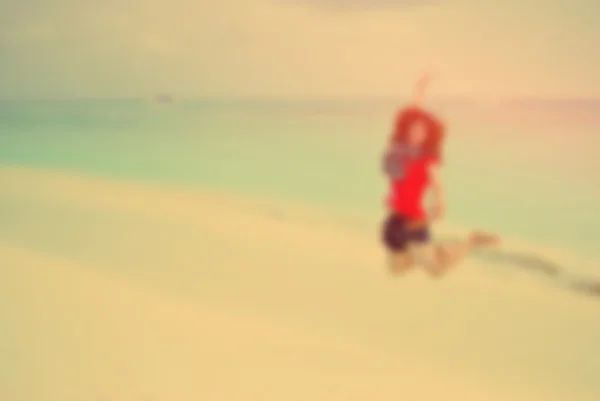 Borrão menina feliz pulando na praia tropical — Fotografia de Stock