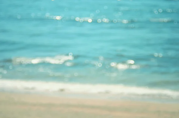 Sfocatura spiaggia tropicale con bokeh sole onda di luce sfondo astratto. Concetto di viaggio . — Foto Stock