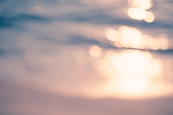 Verschwimmen tropischen Sonnenuntergang Strand mit Bokeh Sonnenlicht Welle abstrakten Hintergrund. Reisekonzept. — Stockfoto