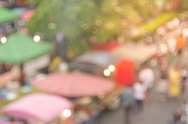 İnsanlar renkli bokeh ve güneş ışık arka plan ile yerel sokak pazarında alışveriş bulanıklık.