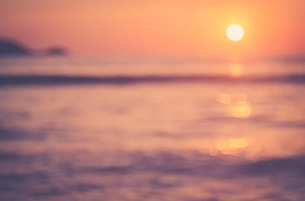 Blur tropical sunset beach with bokeh sun light wave abstract background. Travel concept. — Stock Photo, Image