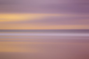 Hareket bulanıklığı tropikal günbatımı plaj ve pürüzsüz dalga. Seyahat kavramı.