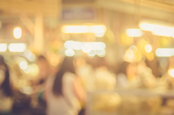 Flou gens faisant du shopping dans le marché de rue local avec bokeh coloré et lumière du soleil fond abstrait . — Photo