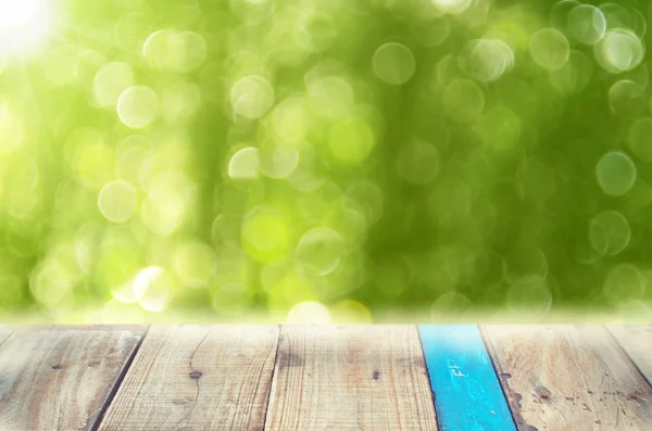 Hoja verde de la naturaleza con luz solar bokeh sobre fondo de mesa de madera viejo vacío . — Foto de Stock