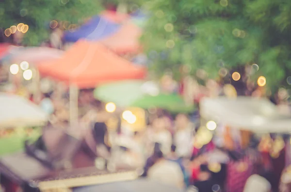 Blur people shopping in local street market with colorful bokeh and sun light abstract background.