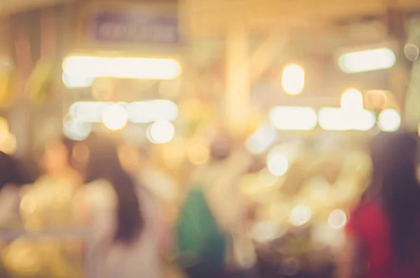 Rozostření lidé nakupování v místním tržišti s barevnými bokeh a sluneční světlo abstraktní pozadí. — Stock fotografie