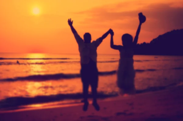 Borrão casal pulando na praia tropical — Fotografia de Stock