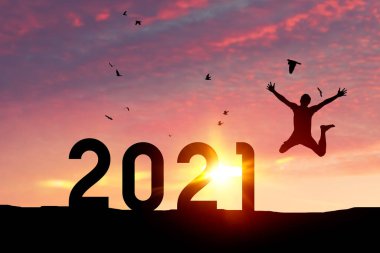 Silüet adam atlıyor ve kuşlar gün batımında dağın tepesinde gökyüzünde uçuyor ve sayı 2021 gibi soyut bir arka plan. Mutlu yıllar ve bayram kutlamaları. Klasik ton filtresi renk biçimi.