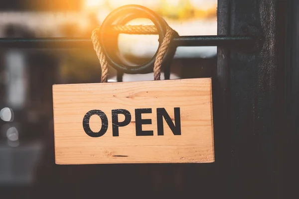 Open sign hanging front of cafe with colorful bokeh light abstract background. Business service and food concept. Vintage tone filter effect color style.