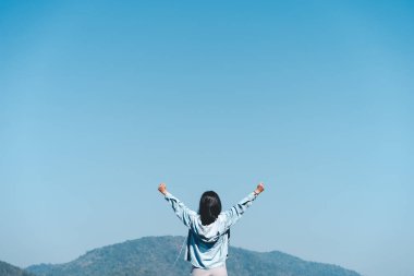 Kadının boşluğunu kopyala. Dağın tepesinde elini kaldır ve mavi gökyüzü bulutu soyut arkaplan. Özgürlük iyi hissettiriyor ve seyahat macerası tatili konsepti. Klasik ton filtre efekti renk biçimi