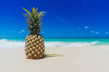 Tropik plaj arka planında ananas. Yaz tatili ve sağlıklı gıda konsepti. 