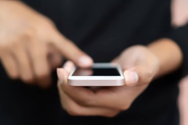 Adam el yakından tutun park açık sokak arka plan üzerinde akıllı telefon kullanarak. Teknoloji iş alanı kopyalayın ve tatil kavramı seyahat. Vintage sesi filtre efekti renk stili.