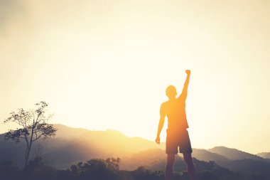 İnsan elinin dağın tepesine yükselişini ve günbatımı gökyüzünün soyut arkaplanını kopyala. Özgürlük yolculuğu macerası ve iş zaferi kavramı. Klasik ton filtre efekti renk biçimi.