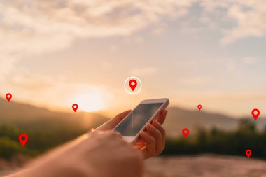 Dağın tepesinde navigasyon noktası soyut arkaplanı olan akıllı telefon kullanan bir adam. Teknoloji işi ve seyahat macerası konsepti. Klasik ton filtre efekti renk biçimi.