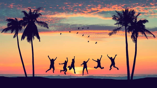 Silhouette Boldog Barátok Ugrás Naplemente Trópusi Strandon Pálmafa Madarak Repülő — Stock Fotó