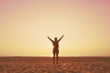 Sahilde ve adada, günbatımında gökyüzünde yükselen kadın mekânını kopyalayın. Özgürlük ve seyahat macera konsepti. Klasik ton filtre efekti renk biçimi.