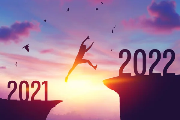 2021 'den 2022' ye kadar uçurumun arasında uçan siluet adam ve dağın tepesinde uçan kuşlar. Özgürlük mücadelesi ve seyahat macera tatili konsepti. Klasik ton filtre efekti renk biçimi.