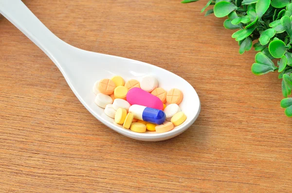 Muitos comprimidos de medicina colorida na colher — Fotografia de Stock