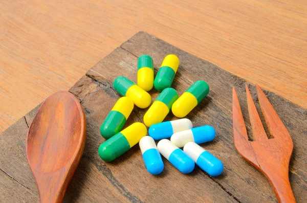 Medicamento pílula cápsula com colher e garfo — Fotografia de Stock