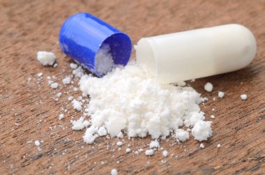 ahşap arka plan üzerinde toz ilaç kapsül pill açıldı