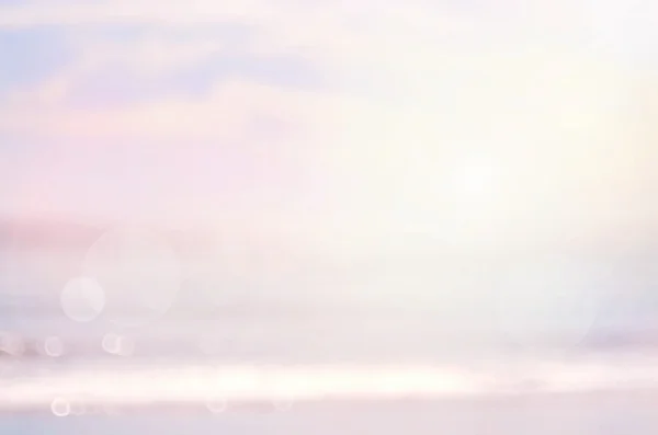 Размытый пляж с голубым небом на фоне . — стоковое фото