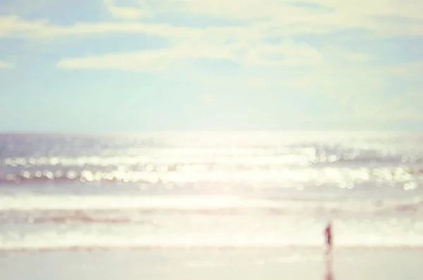 Muž na pláži s bokeh vlna abstraktní pozadí rozostření. — Stock fotografie
