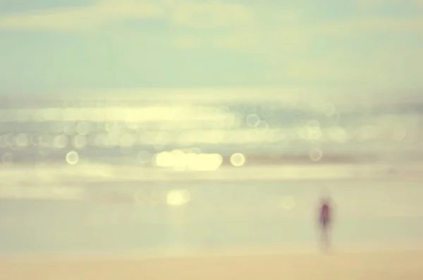 Borrão homem na praia com bokeh onda abstrato fundo . — Fotografia de Stock