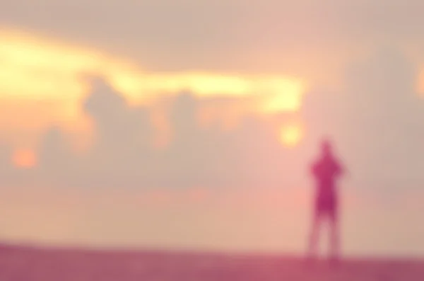 Desenfoque hombre en tropical atardecer playa abstracto fondo . — Foto de Stock