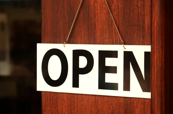 Cartel abierto amplio colgando en la puerta de madera en la cafetería de la calle . — Foto de Stock