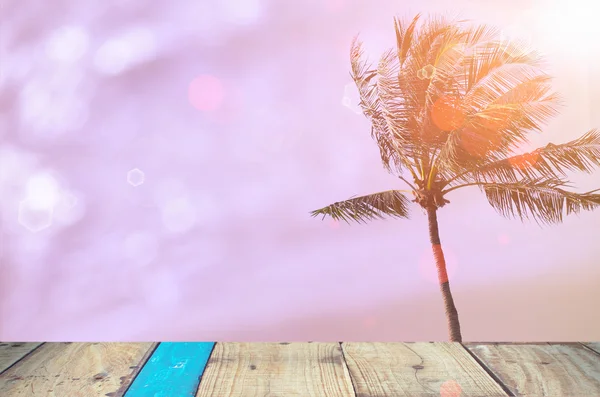 Vervagen tropische zonsondergang strand met oude houten tafel achtergrond. — Stockfoto