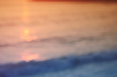 Tropikal günbatımı plaj ile bokeh ışık dalga arka plan bulanıklık.