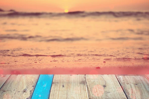 Розмитий пляж тропічного заходу сонця зі старим порожнім дерев'яним столом . — стокове фото