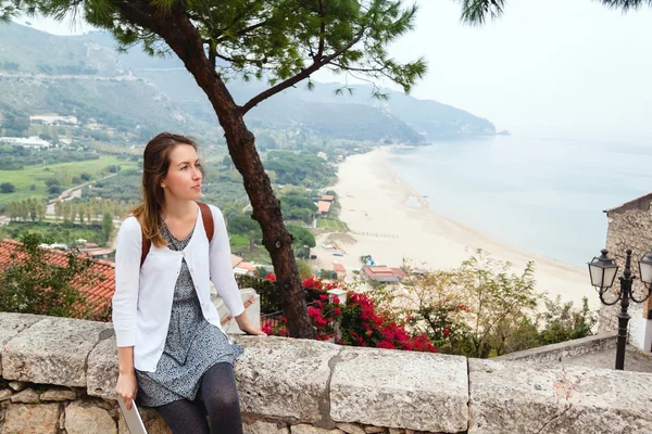 Young girl sitting in front of panoramic view of Sperlonga. Italy — Stock Photo, Image
