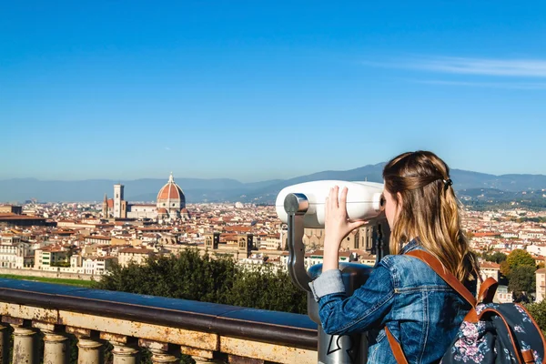 Junges Mädchen blickt durch ein Münzfernglas und genießt die Aussicht auf Florenz, Toskana, Italien. — Stockfoto