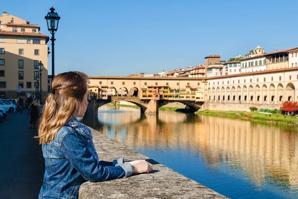Junges Mädchen genießt die Aussicht auf die Ponte Vecchio in Florenz, Toskana, Italien. — Stockfoto