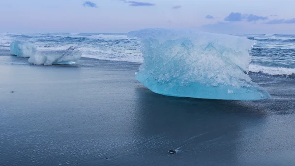 Eisberg über schwarzem Sandstrand in Jakulsarlon, Eislandschaft — Stockfoto