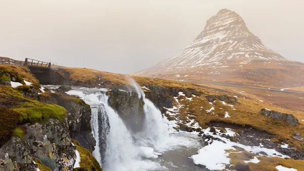 Vulcão Monte Kirkjufell com pequena cachoeira em dia nublado e chuvoso — Fotografia de Stock