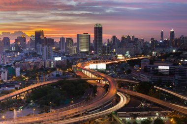 Otoyol kavşağı ve şehir şehir üzerinde güneş battıktan sonra dramatik gökyüzü