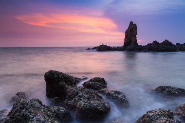 Kayalık sahil dramatik gökyüzü ile uzun pozlama 