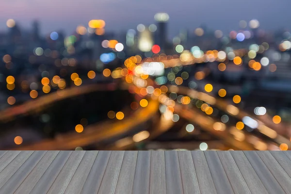 Apertura de piso de madera, abstracto borrosa bokeh luces de la ciudad y la intersección de carreteras — Foto de Stock