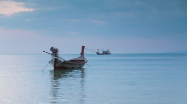 Sahil manzarası içinde oturan long tail tekne