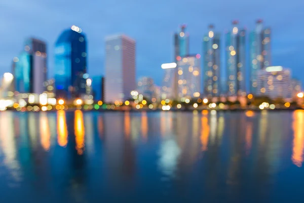 Edifício de escritório borrado luzes vista à beira-mar noite, fundo abstrato — Fotografia de Stock