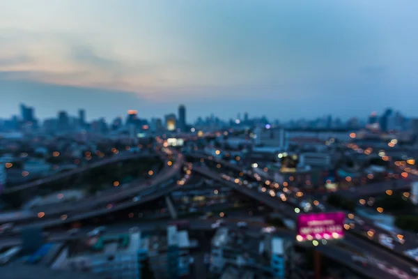 Wazig lights aerial view, stad en snelweg snijpunt na zonsondergang, abstracte bokeh achtergrond — Stockfoto