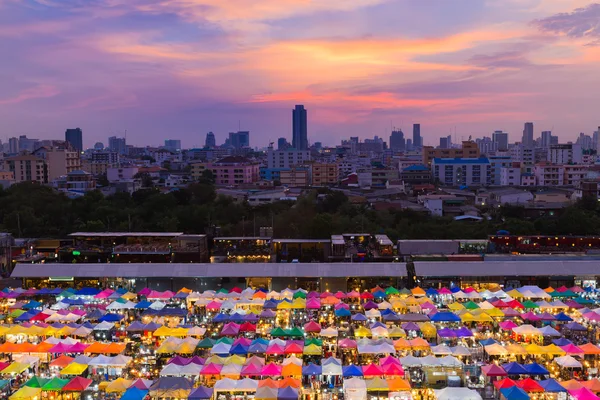 Vista aérea colorida mercado de pulgas com centro da cidade e céu dramático — Fotografia de Stock