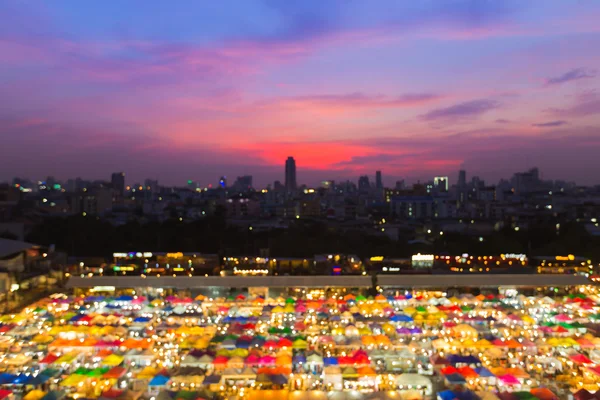 Абстрактно размытые боковые фары с видом на крышу ночного рынка, многоцветный фон — стоковое фото