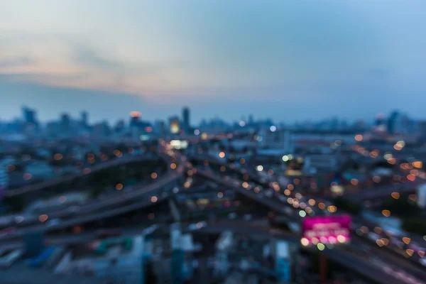 Luces borrosas, el fondo del centro de la ciudad y la carretera intercambiados después del atardecer — Foto de Stock