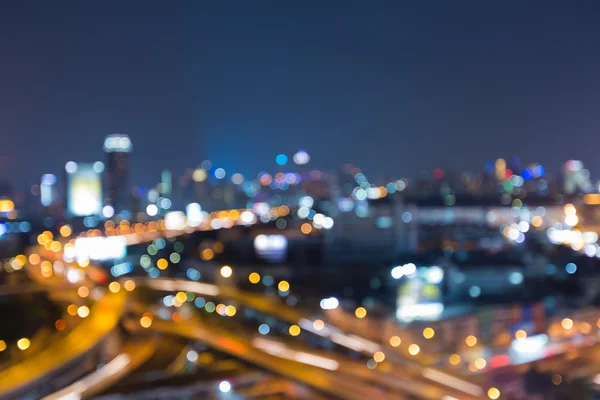 Luces borrosas, carretera de la ciudad intercambiada y el fondo del edificio de oficinas, vista nocturna — Foto de Stock